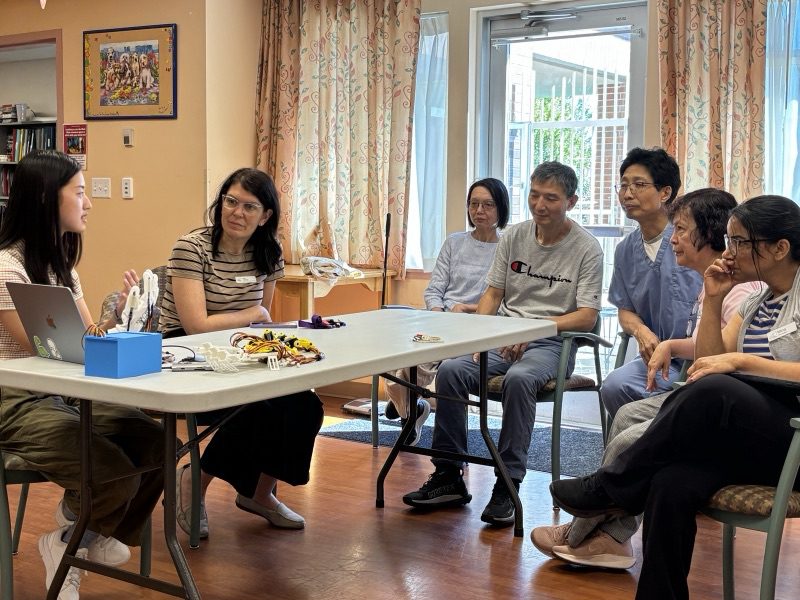 A group of participants seated in a circle around a table during a Ripple session